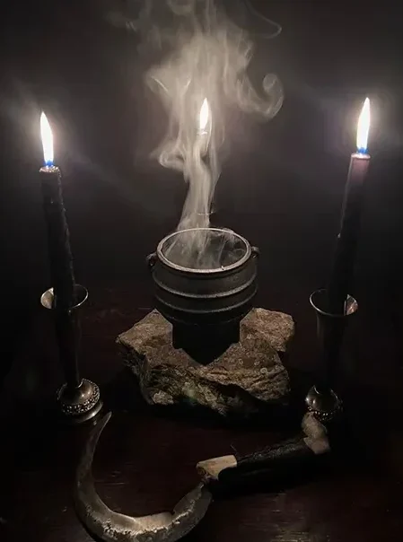 Candles, ritual items, and incense smoke on a witchcraft altar during a spellcasting ceremony