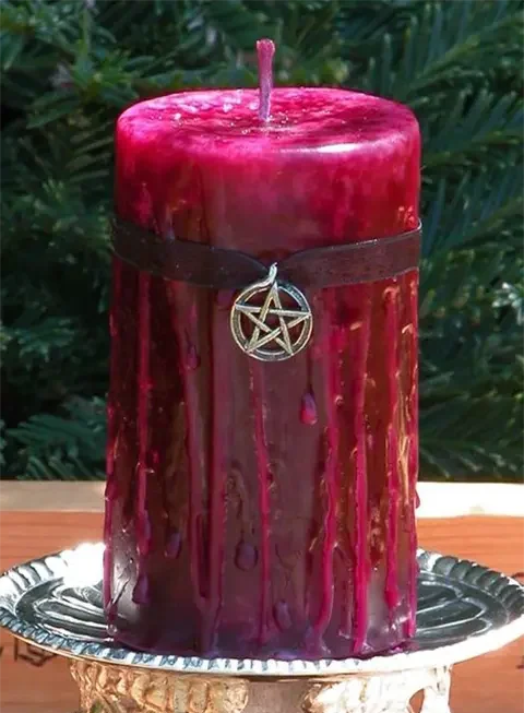 Red witchcraft candle with pentagram symbol used in powerful marriage spell ritual