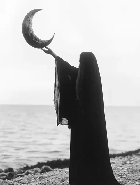 Woman in traditional dress with arms open toward the moon, symbolizing forgiveness and reconciliation spell on Chalice Magick
