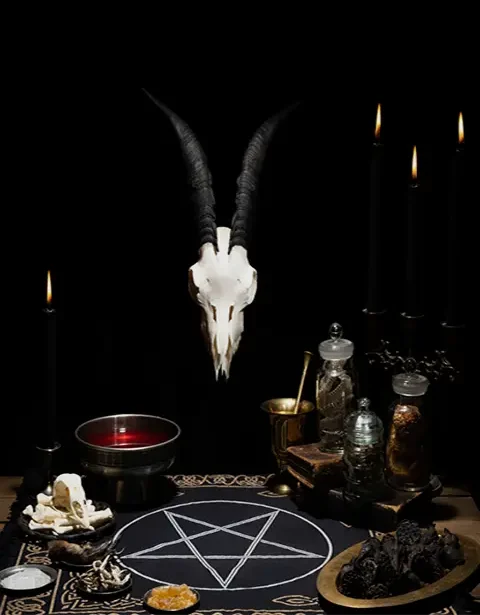 Black magic altar with goat skull and ritual objects for demonic pact
