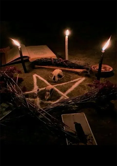 Witchcraft book with candles and ritual items used in magical spells and occult practices