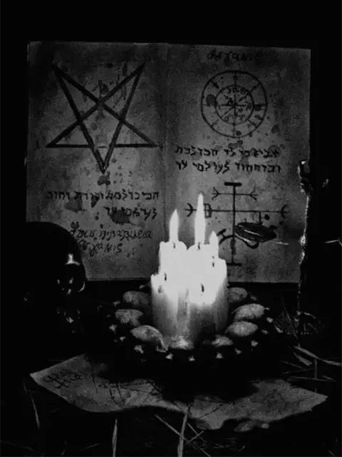 Ancient manuscript with melted candles in a dark setting